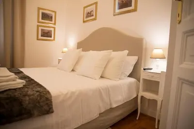 a bedroom with a bed with white pillows and a night stand at St Paul House Boutique & Apartment in Rome