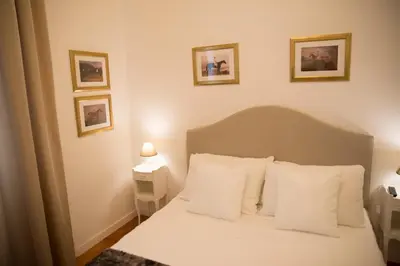 a bedroom with a bed with white sheets and pillows at St Paul House Boutique & Apartment in Rome