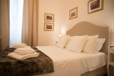 a bedroom with a bed with white sheets and pillows at St Paul House Boutique & Apartment in Rome