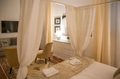 a bedroom with two beds and a dresser and curtains at St Paul House Boutique & Apartment in Rome