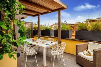 a patio with a white table and chairs on a balcony at Monti Palace Hotel in Rome