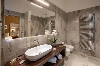 a bathroom with a sink and a toilet and a mirror at Monti Palace Hotel in Rome
