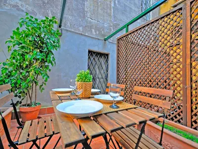 a wooden table and chairs on a patio at Terrace Governo Vecchio in Rome