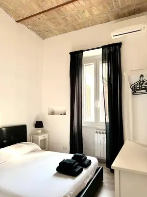 a bedroom with a bed with black curtains and a window at CasualSuiteMachiavelli in Rome
