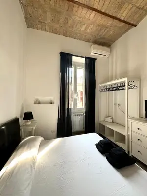 a bedroom with a large white bed and a window at CasualSuiteMachiavelli in Rome