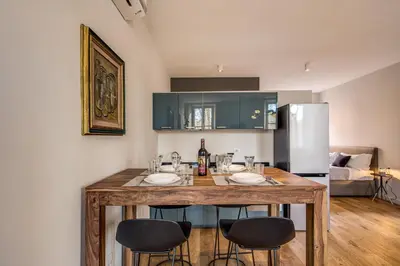 a kitchen with a table with chairs and a refrigerator at Sant'eiligio loft campo di fiori in Rome