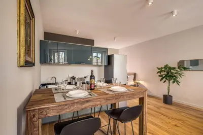 a kitchen with a large wooden island with chairs at Sant'eiligio loft campo di fiori in Rome