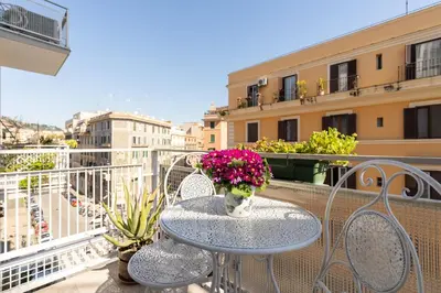 a table and chairs on a balcony with flowers at All'Ombra dei Musei Vaticani in Rome