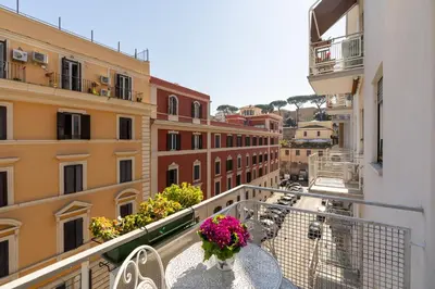 a balcony with a table and chairs and flowers at All'Ombra dei Musei Vaticani in Rome