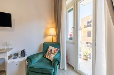 a living room with a green chair and a window at All'Ombra dei Musei Vaticani in Rome