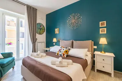a bedroom with a large bed with a blue wall at All'Ombra dei Musei Vaticani in Rome