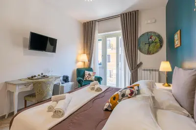 a hotel room with a bed and a desk and a room at All'Ombra dei Musei Vaticani in Rome
