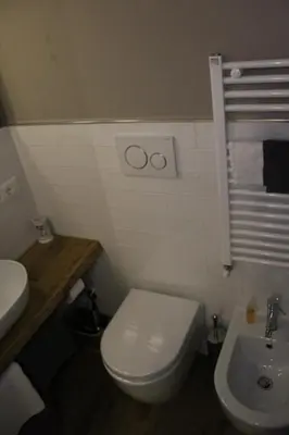 a bathroom with a white toilet and a sink at St. Peter's Luxury Rooms in Rome
