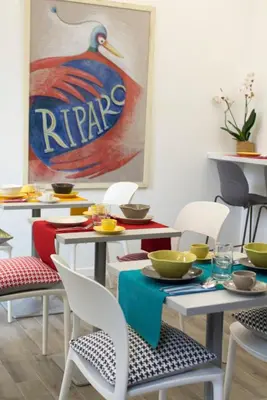 a dining room with tables and chairs and a painting of a rippon sign at Il B&B della Mamma in Rome