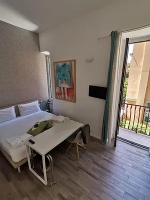 a bedroom with a bed and a table and a balcony at Il B&B della Mamma in Rome