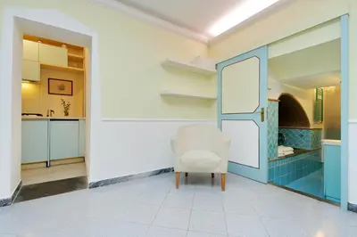 a white chair in a room with a kitchen at Characteristic apartment just beside the Vatican in Rome