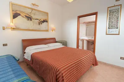 a bedroom with a bed and a painting on the wall at B&B Babri Simim Taj in Rome