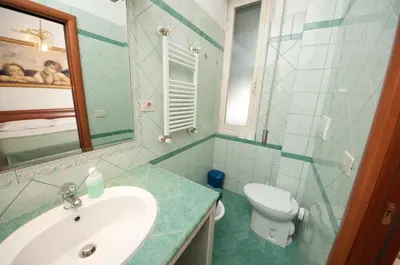 a bathroom with a sink and a toilet and a mirror at B&B Babri Simim Taj in Rome