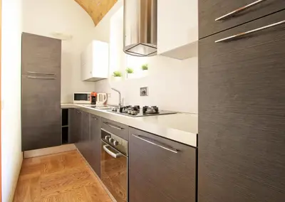 a kitchen with stainless steel appliances and wood cabinets at Maisonette Coppedé in Rome