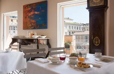 a dining room with a clock and a table with food at Palazzo Caruso in Rome
