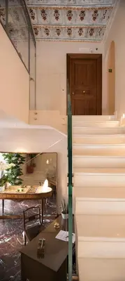 a lobby with stairs and a table and a door at Palazzo Caruso in Rome