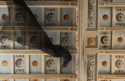 a bird is sitting on a wall with decorations at Palazzo Caruso in Rome