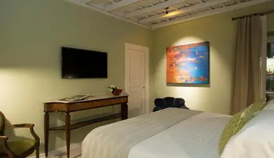 a bedroom with a bed and a desk and a television at Palazzo Caruso in Rome