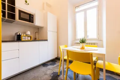a kitchen and dining room with a table and yellow chairs at A casa di Ale e Lalla in Rome