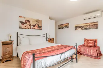 a bedroom with a bed and a chair in it at Il Nido di Lulu in Rome