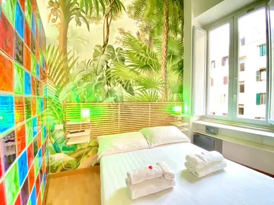 a bedroom with a tropical mural on the wall at KISS ME ROME Luxury Rooms in Rome