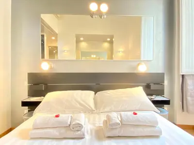 a bedroom with a large mirror above a bed at KISS ME ROME Luxury Rooms in Rome