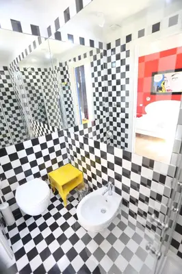 a checkered bathroom with a sink and a mirror at KISS ME ROME Luxury Rooms in Rome