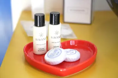 a red tray with two bottles of shampoo and two donuts at KISS ME ROME Luxury Rooms in Rome
