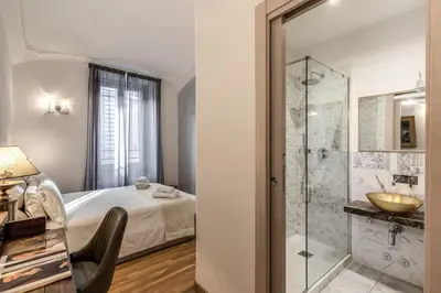 a bathroom with a bed and a glass shower at Biancalunagiulia in Rome