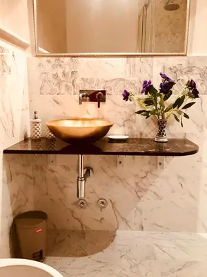 a bathroom with a sink and a vase of flowers at Biancalunagiulia in Rome