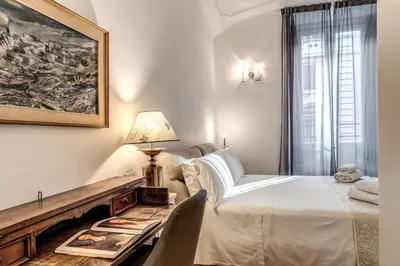 a bedroom with a bed and a table with a chair at Biancalunagiulia in Rome