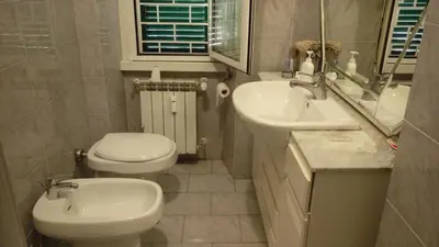 a bathroom with a sink and a toilet and a mirror at Varese Guest House in Rome