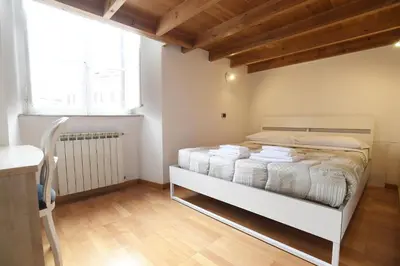 a bedroom with a bed with white sheets and a window at Lo Chalet in Rome
