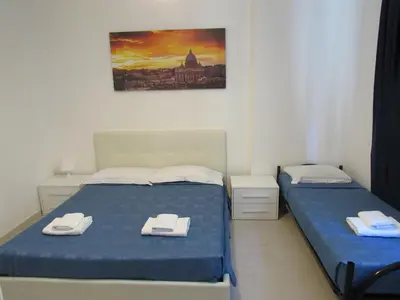 a bedroom with two beds and a painting on the wall at PIANETA ROMA 39 in Rome