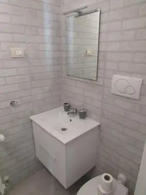 a white bathroom with a sink and a toilet at PIANETA ROMA 39 in Rome