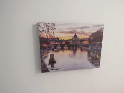 a painting hanging on a wall with a view of a river at PIANETA ROMA 39 in Rome