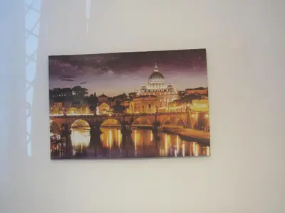 a painting of a bridge and the vatican on a wall at PIANETA ROMA 39 in Rome