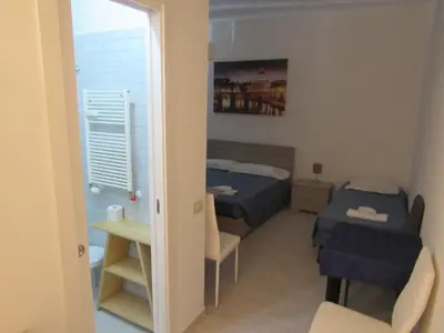 a small room with a bed and a table and chairs at PIANETA ROMA 39 in Rome