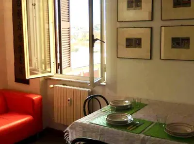 a table in a room with a red chair and a window at Porto Fluviale House in Rome