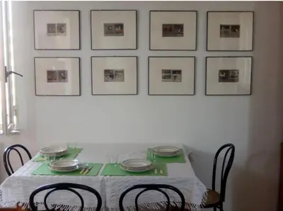 a dining room table with chairs and pictures on the wall at Porto Fluviale House in Rome