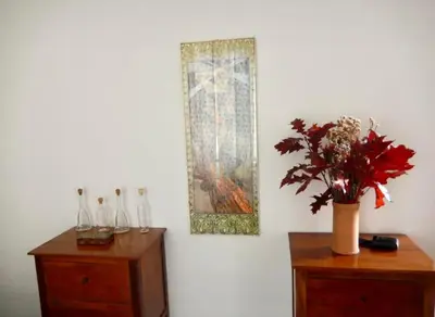 a painting on a wall with a vase of flowers on a dresser at Porto Fluviale House in Rome