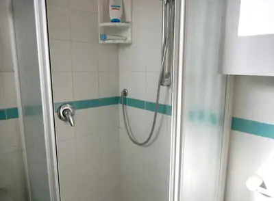 a bathroom with a shower with blue and white tiles at Porto Fluviale House in Rome