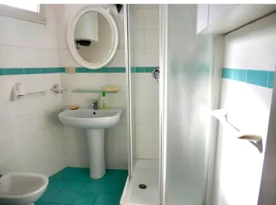 a bathroom with a sink and a mirror and a shower at Porto Fluviale House in Rome