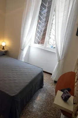 a bedroom with a bed and a window at Maison Colosseo (Via dei Querceti 24) in Rome