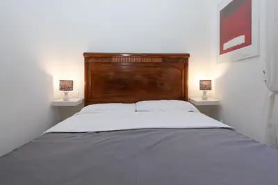 a bedroom with a large bed with two lamps on both sides at Maison Colosseo (Via dei Querceti 24) in Rome
